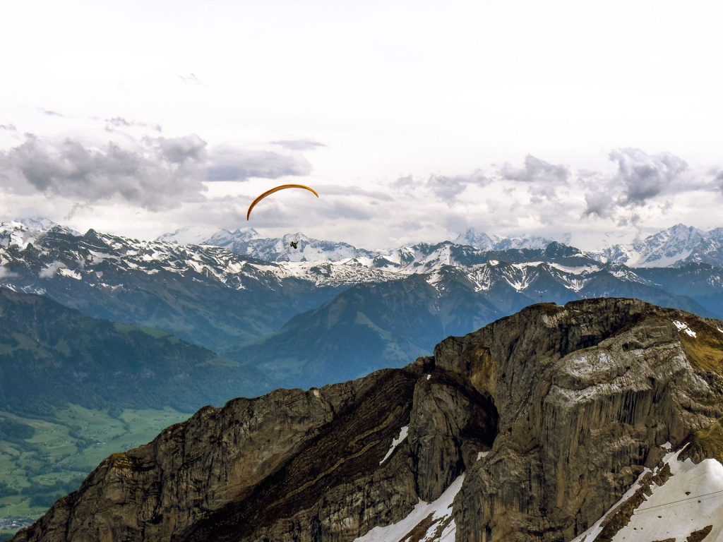 Décollage en parapente au-dessus d’une vallée montagneuse