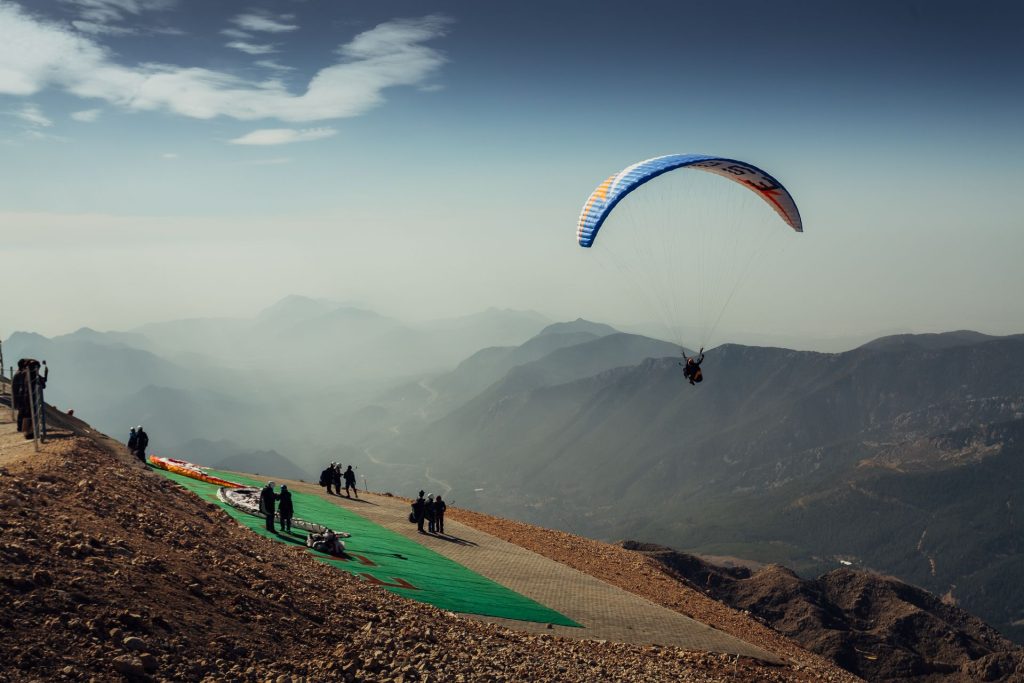 Préparation d’un décollage en parapente sur un versant de montagne
